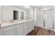 Bathroom featuring double vanity, quartz countertop, and glass-enclosed shower at 9151 Telluride Ct, Commerce City, CO 80022