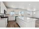 This kitchen features white cabinets, stainless appliances, a large island, and sliding glass doors to a patio at 9151 Telluride Ct, Commerce City, CO 80022