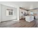 Open-concept area featuring a bright kitchen with white cabinetry, a center island, and modern appliances at 9151 Telluride Ct, Commerce City, CO 80022