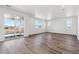 Bright living space with wood floors, natural light from large windows, and sliding glass doors to a patio at 9151 Telluride Ct, Commerce City, CO 80022