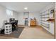 Basement featuring a desk, storage shelves, and kitchenette area with neutral carpeting at 3261 Kassler Pl, Westminster, CO 80031