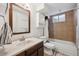 Well-lit bathroom featuring a dark vanity, a tiled shower, and ample storage space at 3261 Kassler Pl, Westminster, CO 80031