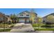 Two-story home with a three car garage, well-manicured lawn, and beautiful tree in the front yard at 26861 E Clifton Dr, Aurora, CO 80016