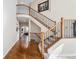 Open foyer with hardwood floors, staircase with wrought iron railing, and views into adjacent living spaces at 26861 E Clifton Dr, Aurora, CO 80016