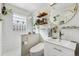 Modern bathroom with a glass-enclosed shower, white vanity, and stylish round mirror at 2024 Ford St, Golden, CO 80401