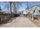 Spacious driveway leading to a backyard with mature trees and a glimpse of the home's exterior at 2024 Ford St, Golden, CO 80401