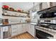 Functional kitchen features stainless steel appliances, floating shelves, and a bright window at 2024 Ford St, Golden, CO 80401