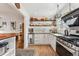 Updated kitchen with stainless steel appliances, open shelving, and a view into the dining area at 2024 Ford St, Golden, CO 80401