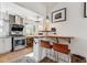 Cozy kitchen featuring a breakfast bar, stainless steel appliances, and stylish backsplash at 2024 Ford St, Golden, CO 80401