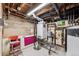 Basement utility room with a modern water heater, exposed pipes, and a painted concrete floor at 2024 Ford St, Golden, CO 80401