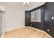 Dining area with wood floors, black accent wall, and a large window at 3200 S Federal Blvd # 5, Denver, CO 80236