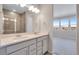 Double vanity bathroom with shower and view into bedroom at 16783 W 94Th Way, Arvada, CO 80007