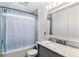 Bathroom featuring a vanity with a stone countertop, a shower/tub combo with a curtain, and a large mirror at 370 S Parfet St, Lakewood, CO 80226