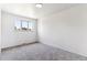 An empty carpeted bedroom with neutral walls and bright natural light from a large window at 370 S Parfet St, Lakewood, CO 80226