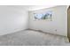 Bright bedroom featuring plush carpet, a large window, and neutral walls at 370 S Parfet St, Lakewood, CO 80226