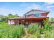 Back exterior of a brick two-story home features an expansive covered patio and mature landscaping at 370 S Parfet St, Lakewood, CO 80226