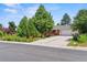 Charming single-story home with lush trees, a well-manicured lawn, and a long, wide driveway at 370 S Parfet St, Lakewood, CO 80226