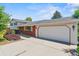 An attached garage is shown in this exterior view of this home with a brick facade at 370 S Parfet St, Lakewood, CO 80226