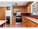 Well-lit kitchen features wooden cabinets, stainless steel appliances, and a brick backsplash at 370 S Parfet St, Lakewood, CO 80226