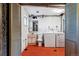 A vintage laundry room features orange flooring, a washer, a dryer, and a utility sink at 370 S Parfet St, Lakewood, CO 80226