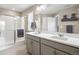 Modern bathroom with dual sinks, quartz countertop, sleek gray cabinetry and a glass enclosed shower at 14100 Shasta Daisy St, Parker, CO 80134