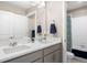 Bathroom featuring double sinks, a quartz countertop, modern fixtures, and a shower/tub combo with a blue curtain at 14100 Shasta Daisy St, Parker, CO 80134