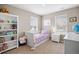 Bright bedroom with a playful decor, white trim, carpeted floors, and lots of natural light from two windows at 14100 Shasta Daisy St, Parker, CO 80134