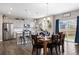 Elegant dining area with modern chandelier, table set, and view of open kitchen and stainless appliances at 14100 Shasta Daisy St, Parker, CO 80134