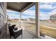 Covered front porch with chairs, offering a relaxing view of the neighborhood and bright blue sky at 14100 Shasta Daisy St, Parker, CO 80134