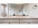 Bathroom features double sinks, modern fixtures, a large mirror, and neutral color palette at 6799 Navajo St, Denver, CO 80221