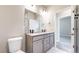 A stylish bathroom boasts double sinks, a large mirror, and sleek gray cabinets at 6799 Navajo St, Denver, CO 80221