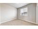 A bright bedroom features neutral paint, carpet, white trim, and a view to the outside at 6799 Navajo St, Denver, CO 80221