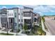 Modern townhome showcases multi-tone color scheme, landscaping, and inviting red door at 6799 Navajo St, Denver, CO 80221