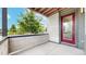 View of covered patio with modern concrete blocks and a red door at 6799 Navajo St, Denver, CO 80221