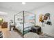 Bright bedroom featuring a four-poster bed, white walls, light colored floors, and a view to the exterior at 6420 W 6Th Ave, Lakewood, CO 80214