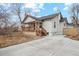 Charming home exterior with a covered porch and a long driveway at 6420 W 6Th Ave, Lakewood, CO 80214