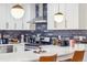 Bright kitchen features white cabinets, stainless steel appliances, dark backsplash and quartz counters at 6420 W 6Th Ave, Lakewood, CO 80214