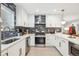 Modern kitchen boasts white cabinetry, stylish backsplash, stainless steel appliances, and ample counter space at 6420 W 6Th Ave, Lakewood, CO 80214