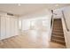 Spacious finished basement with new light-colored flooring and a staircase at 6488 E 63Rd Pl, Commerce City, CO 80022