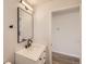 A bathroom featuring a white vanity, black hardware, a black mirror, and updated lighting at 6488 E 63Rd Pl, Commerce City, CO 80022