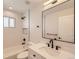 A sleek remodeled bathroom features modern fixtures, a tub and shower combo, and great lighting at 6488 E 63Rd Pl, Commerce City, CO 80022