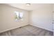 An empty bedroom with carpet flooring and natural light streaming in through the window at 6488 E 63Rd Pl, Commerce City, CO 80022