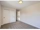 A bedroom with neutral walls, carpet flooring, white closet doors, and natural light at 6488 E 63Rd Pl, Commerce City, CO 80022