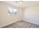 An empty bedroom with carpet flooring and neutral paint, plus a window providing natural light at 6488 E 63Rd Pl, Commerce City, CO 80022