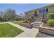 Close-up of the front yard with tiered landscaping and concrete pathway at 6488 E 63Rd Pl, Commerce City, CO 80022