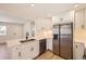 Bright kitchen with stainless steel appliances, white cabinets, and ample counter space at 6488 E 63Rd Pl, Commerce City, CO 80022