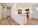 Open concept kitchen with quartz counters, stainless appliances, white cabinetry, and hardwood floors at 6488 E 63Rd Pl, Commerce City, CO 80022
