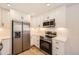 A newly remodeled kitchen featuring stainless steel appliances, white cabinetry, and modern lighting at 6488 E 63Rd Pl, Commerce City, CO 80022