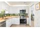 Stylish kitchen featuring white cabinetry, green backsplash, stainless steel appliances and butcher block counters at 1749 Havana St, Aurora, CO 80010
