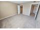 Spacious bedroom with neutral carpet, cream colored walls, and an open closet at 4400 S Quebec St # C107, Denver, CO 80237